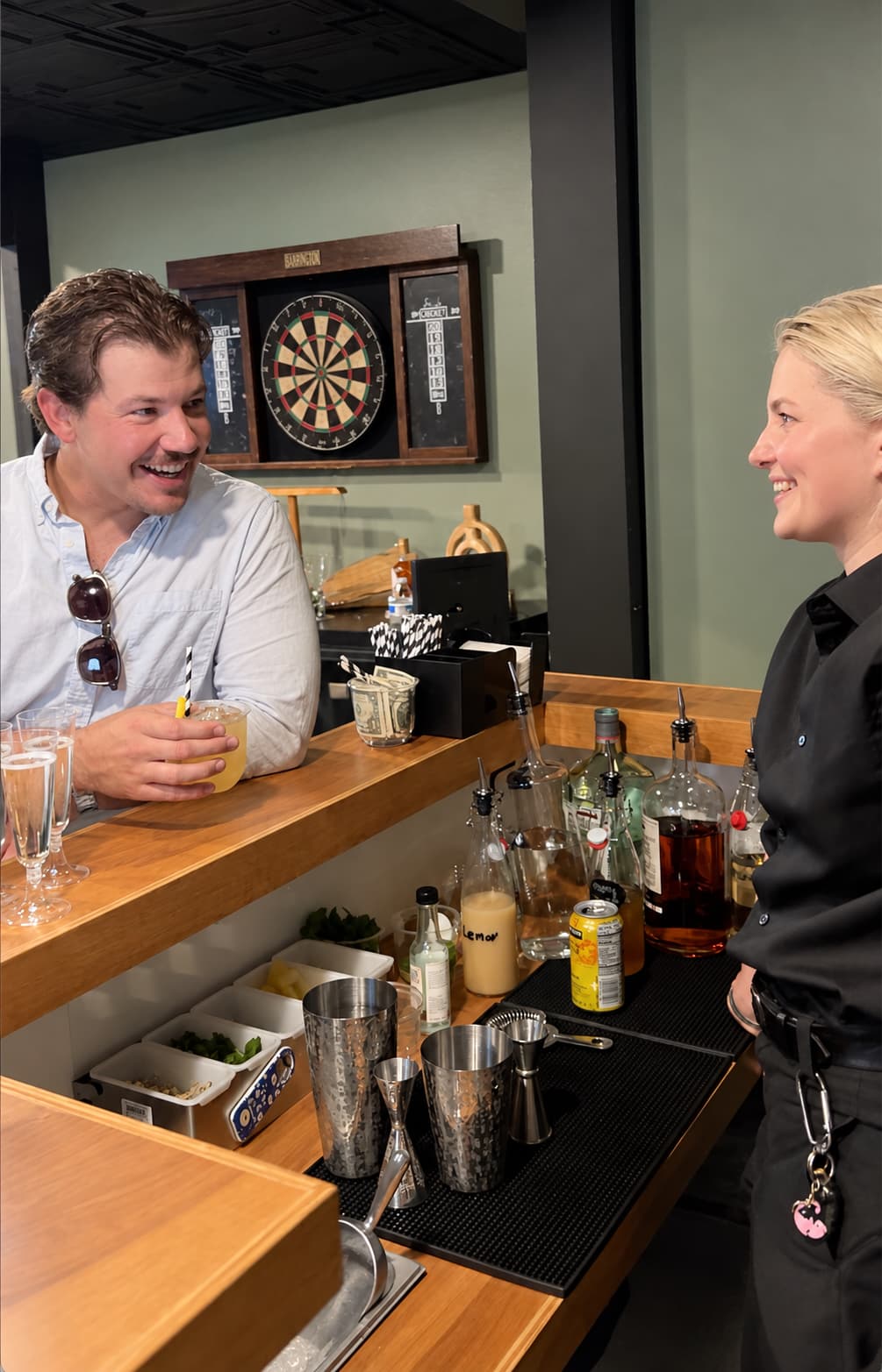 BeeHive bartender chatting with a smiling guest holding a cocktail