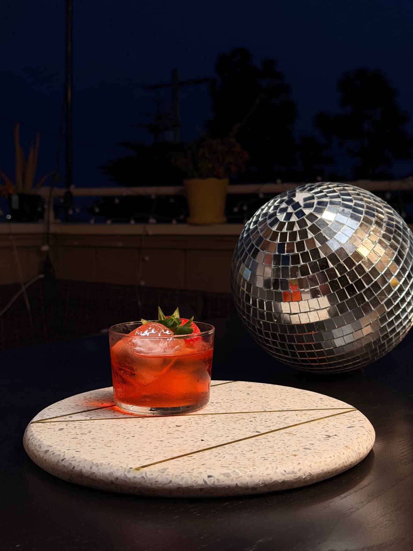 Strawberry Negroni beside a mirrored disco ball