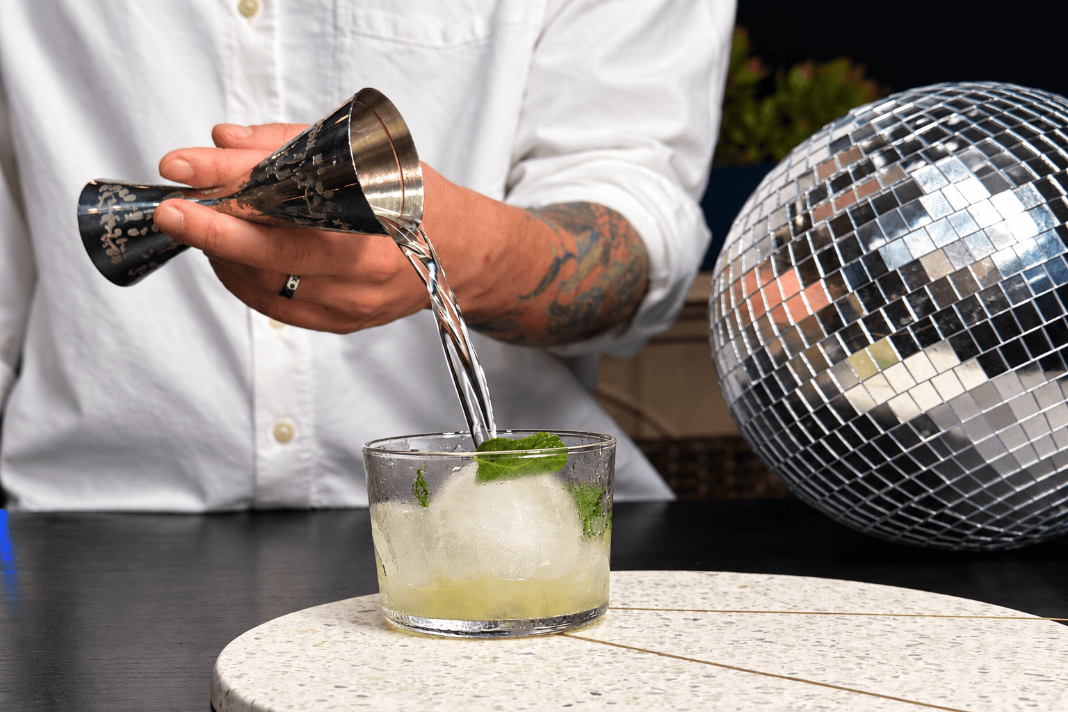 Professional bartender pouring a craft cocktail with precision